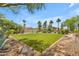 Well-maintained backyard with artificial grass, mature trees, and rock landscaping at 8213 E Sharon Dr, Scottsdale, AZ 85260