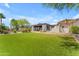 Expansive backyard featuring lush lawn, desert landscaping, and covered patio, ideal for entertaining at 8213 E Sharon Dr, Scottsdale, AZ 85260