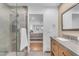 Bathroom with shower, vanity with light wood cabinet, gray counter, and view to primary bedroom at 8213 E Sharon Dr, Scottsdale, AZ 85260