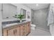 Modern bathroom featuring double sinks, a walk-in shower, and stylish gray tiling and fixtures at 8213 E Sharon Dr, Scottsdale, AZ 85260