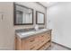 Bathroom with a double sink vanity with gray counter, wood cabinets, and two mirrors at 8213 E Sharon Dr, Scottsdale, AZ 85260