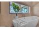 A close up of the soaking tub in the bathroom with natural light and fixtures at 8213 E Sharon Dr, Scottsdale, AZ 85260