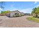 Paver driveway leads to a bright stucco home with an attached three car garage at 8213 E Sharon Dr, Scottsdale, AZ 85260