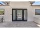 Welcoming entrance with sleek black framed doors leading to the interior of the home with a patio at 8213 E Sharon Dr, Scottsdale, AZ 85260