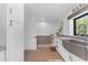 Well-lit laundry room featuring a large farmhouse sink, ample counter space, and an adjacent shower area at 8213 E Sharon Dr, Scottsdale, AZ 85260