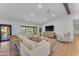 Open-concept living room featuring a large sectional sofa, hardwood floors, and plenty of natural light at 8213 E Sharon Dr, Scottsdale, AZ 85260
