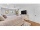 Bright main bedroom featuring white walls, wood floors, neutral bedding, and sliding glass doors to outdoor area at 8213 E Sharon Dr, Scottsdale, AZ 85260