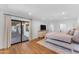 Bright main bedroom with wood floors, white walls, neutral bedding, large windows and sliding glass doors to outside at 8213 E Sharon Dr, Scottsdale, AZ 85260