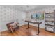 Stylish home office featuring modern wallpaper, hardwood floors, and a sleek adjustable desk at 8213 E Sharon Dr, Scottsdale, AZ 85260