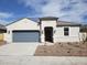 Charming single-story home with blue garage door, desert landscaping and covered entryway at 8422 W Mantle Way, Florence, AZ 85132