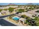 Aerial view of a community showcasing houses with tiled roofs, desert landscaping, and a private pool in one of the backyards at 8848 E Conquistadores Dr, Scottsdale, AZ 85255