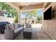 Covered back patio with comfortable seating, BBQ, and outdoor TV at 8848 E Conquistadores Dr, Scottsdale, AZ 85255
