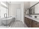 Bathroom featuring double sinks, stylish dark wood cabinetry, soaking tub, and glass shower at 8848 E Conquistadores Dr, Scottsdale, AZ 85255