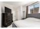 Bedroom features a large window, TV and sleek wood dresser for ample storage and style at 10625 S 55Th Dr, Laveen, AZ 85339