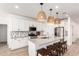 Modern kitchen featuring white cabinets, an island with seating, pendant lighting, and stainless steel appliances at 10625 S 55Th Dr, Laveen, AZ 85339