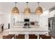 Modern kitchen with an island with bar stool seating, stylish pendant lighting, and stainless steel appliances at 10625 S 55Th Dr, Laveen, AZ 85339