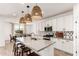 Modern kitchen featuring white cabinetry, an island with bar stool seating, pendant lighting, and sleek appliances at 10625 S 55Th Dr, Laveen, AZ 85339