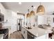 Contemporary kitchen with white cabinets, island seating, pendant lighting, and open layout to living area at 10625 S 55Th Dr, Laveen, AZ 85339