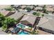Aerial view featuring a backyard with a private swimming pool, lush landscaping, and surrounding neighborhood at 11318 W Monte Vista Rd, Avondale, AZ 85392