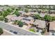 Expansive aerial view of homes with solar panels, surrounded by trees and green spaces in a suburban neighborhood at 11318 W Monte Vista Rd, Avondale, AZ 85392