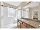 A bathroom with double sinks, granite countertops, and a glass-enclosed shower at 11318 W Monte Vista Rd, Avondale, AZ 85392