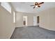 A spacious bedroom featuring a ceiling fan, neutral paint, and an ensuite bathroom at 11318 W Monte Vista Rd, Avondale, AZ 85392