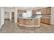 A kitchen with granite countertops, wood cabinets, tile backsplash, stainless steel appliances and a center island at 11318 W Monte Vista Rd, Avondale, AZ 85392