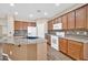 An open-concept kitchen with granite countertops, stainless steel appliances, wood cabinets, and an island at 11318 W Monte Vista Rd, Avondale, AZ 85392