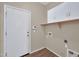 Convenient laundry room with overhead cabinets and a door to the exterior at 11318 W Monte Vista Rd, Avondale, AZ 85392