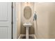 Powder room featuring pedestal sink, oval mirror, wood-look flooring, and neutral paint at 1367 S Country Club Dr # 1331, Mesa, AZ 85210