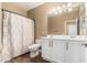 Well-lit bathroom with a double sink vanity, shower with patterned curtain, and wood-look flooring at 1367 S Country Club Dr # 1331, Mesa, AZ 85210