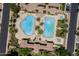 This aerial view showcases a community pool with palm trees, a spa, lounge chairs and meticulously designed landscaping at 1367 S Country Club Dr # 1331, Mesa, AZ 85210