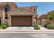 Tan home featuring a two-car garage, pedestrian gate and colorful flowers at 1367 S Country Club Dr # 1331, Mesa, AZ 85210