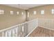 Upstairs landing featuring wood-look flooring, multiple windows, and white railing at 1367 S Country Club Dr # 1331, Mesa, AZ 85210
