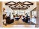 Elegant living room featuring high ceilings, exposed beams, stone fireplace, and luxurious leather furniture at 1367 S Country Club Dr # 1331, Mesa, AZ 85210