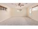 Neutral bedroom offers a ceiling fan, neutral paint, three windows, and a large carpeted floor space at 152 W 2Nd St, Mesa, AZ 85201