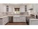 Well-lit kitchen showcasing white cabinets, marble countertops, a farmhouse sink, and stainless steel appliances at 152 W 2Nd St, Mesa, AZ 85201