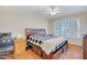 Bedroom with a ceiling fan, wood floors, shuttered windows and platform bed with storage drawers at 15314 W Pantano Dr, Surprise, AZ 85374
