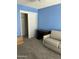 Carpeted living room with a convertible couch, a desk, and ample storage space in closet at 1734 W Tuckey Ln # 14, Phoenix, AZ 85015