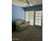 Cozy room features a light sofa, blue walls, ceiling fan, and sliding door to the outside at 1734 W Tuckey Ln # 14, Phoenix, AZ 85015