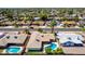 Aerial view showcases a pool home in a suburban neighborhood with green lawns and mature palm trees at 1862 E Tulane Dr, Tempe, AZ 85283