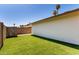 Wide shot of the backyard that includes artificial turf, a brick wall, and palm trees at 1862 E Tulane Dr, Tempe, AZ 85283