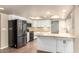 Bright kitchen featuring white cabinetry, stainless steel appliances, granite countertops and a skylight at 1862 E Tulane Dr, Tempe, AZ 85283