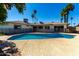 Wide shot of the fenced in pool, palm trees, blue sky, and back of the home at 1862 E Tulane Dr, Tempe, AZ 85283