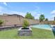 A serene backyard featuring artificial grass, a refreshing pool with waterfall feature, and a decorative planter at 19606 W Grant St, Buckeye, AZ 85326