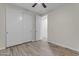 Bright bedroom with wood-look floors, a ceiling fan, and a closet at 19606 W Grant St, Buckeye, AZ 85326