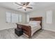 Inviting bedroom with a wooden bed, ceiling fan, and abundant natural light at 19606 W Grant St, Buckeye, AZ 85326