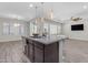 Bright kitchen island with bar stools, stainless steel sink, and open living space at 19606 W Grant St, Buckeye, AZ 85326