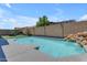 Sparkling pool features a rock waterfall, providing a serene backyard oasis for relaxation and recreation at 19606 W Grant St, Buckeye, AZ 85326