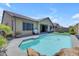 Backyard oasis featuring a sparkling pool with rock accents and a covered patio at 19606 W Grant St, Buckeye, AZ 85326